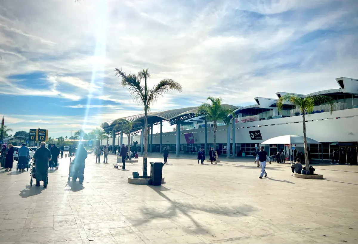 Real photograph of travelers outside Terminal 2 at Casablanca Mohammed V Airport