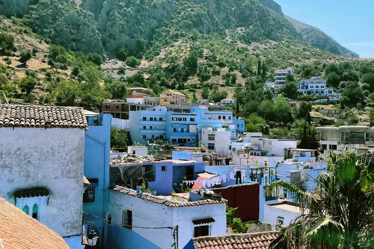 Blue and white Chefchaouen homes below the rocky Rif Mountains