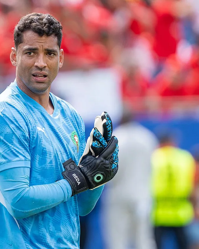 Ahmed Reda Tagnaouti applauding in a blue goalkeeper kit