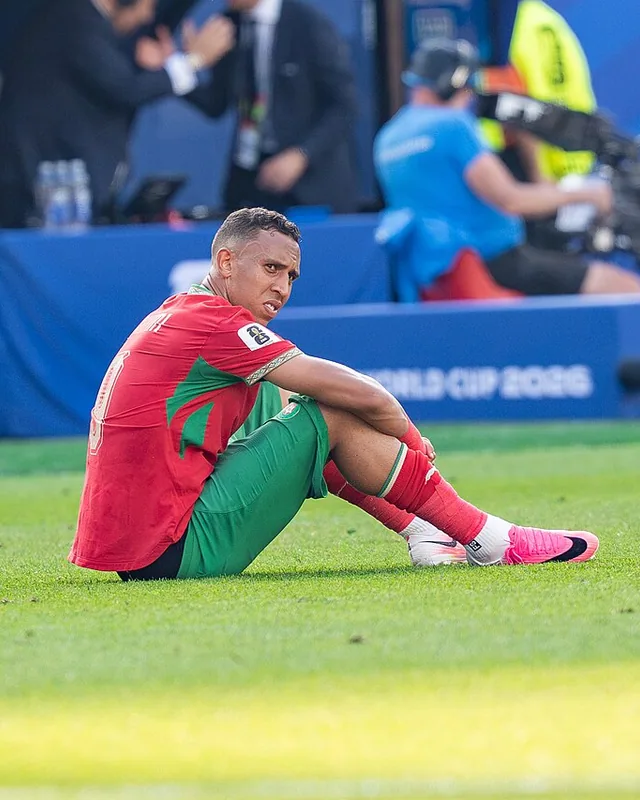 Soufiane Rahimi sitting on the pitch in Morocco kit after a match